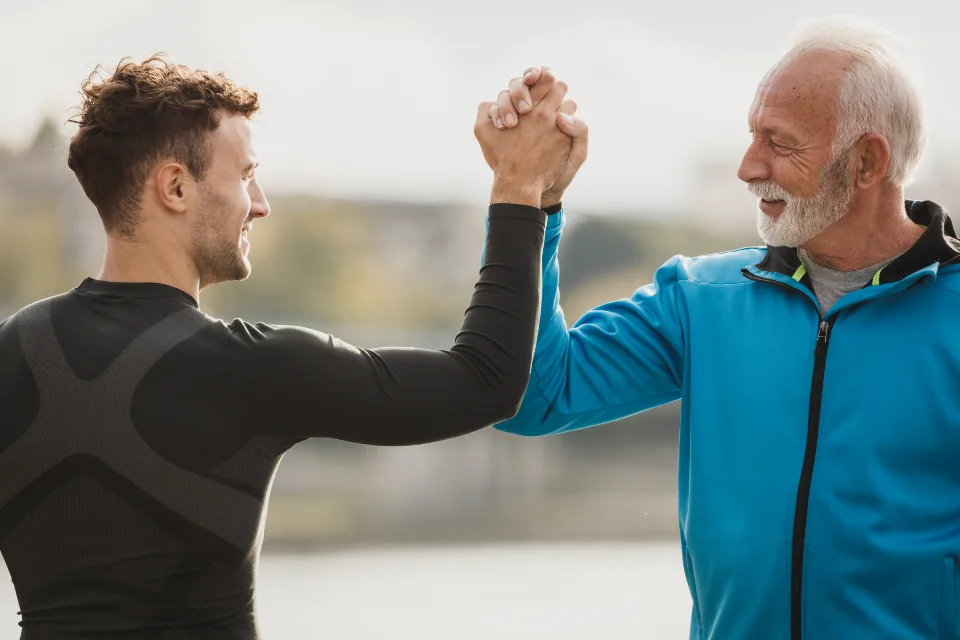 Dos jugadores de distintas generaciones chocando la mano tras un partido